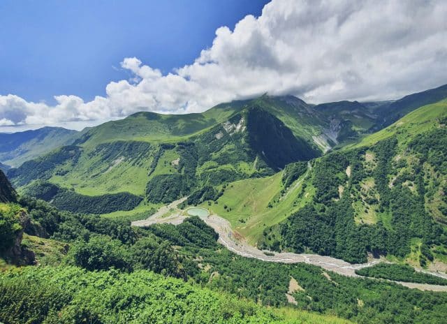 A picture depicting a breathtaking view of mountains covered in lush green grass.

